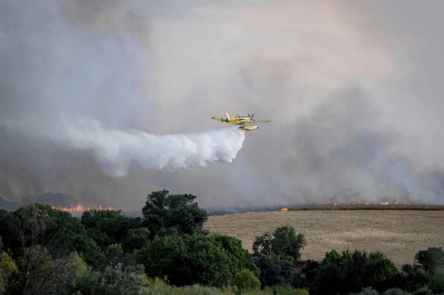  A firefighting plane drops water during efforts to extinguish a wildfire near Navalcarnero, on the outskirts of Madrid, Spain, Thursday, July 17, 2025. (A. Pérez Meca/Europa Press via AP) 