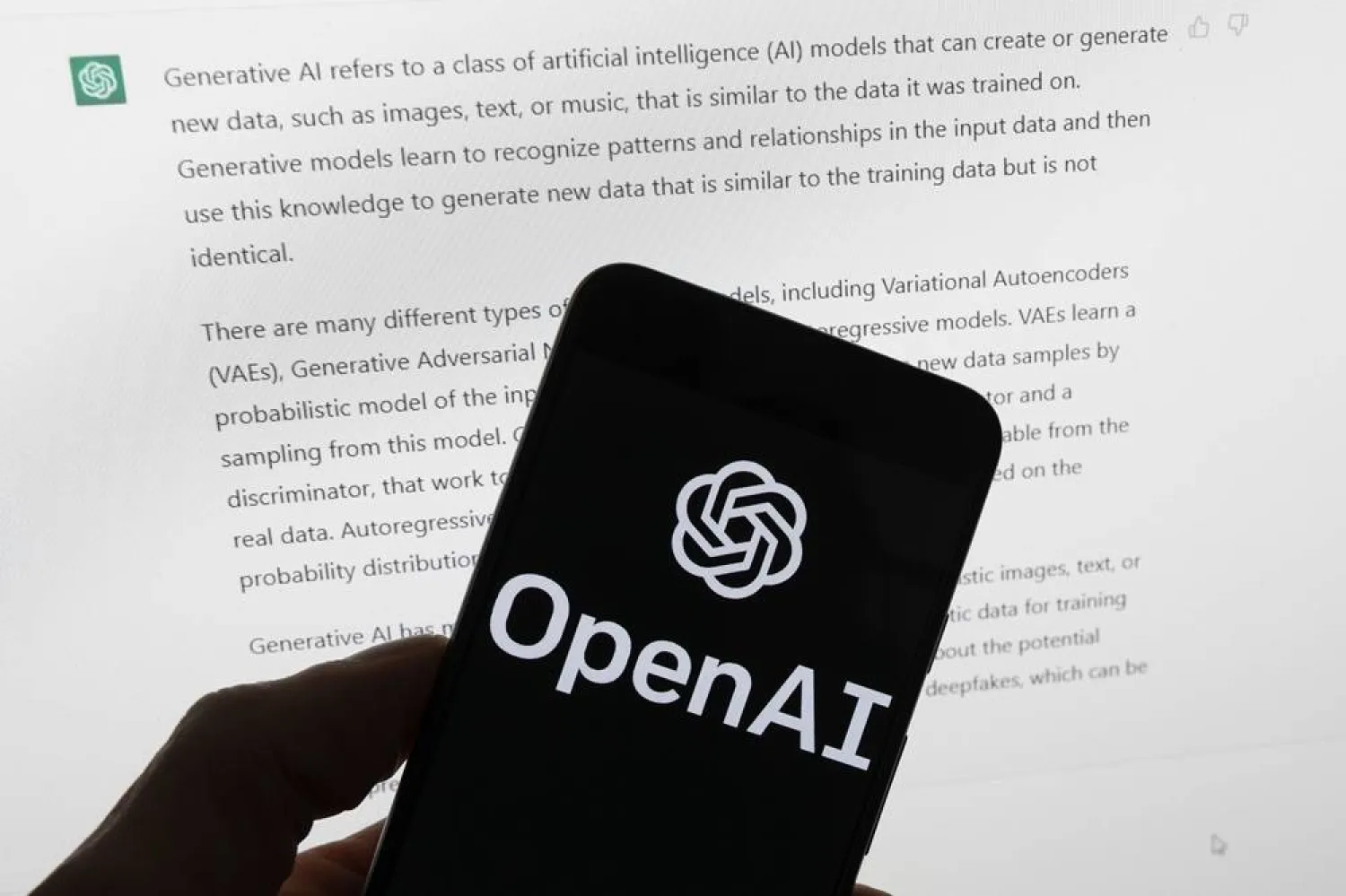 The OpenAI logo is seen on a mobile phone in front of a computer screen displaying output from ChatGPT, March 21, 2023, in Boston. (AP)