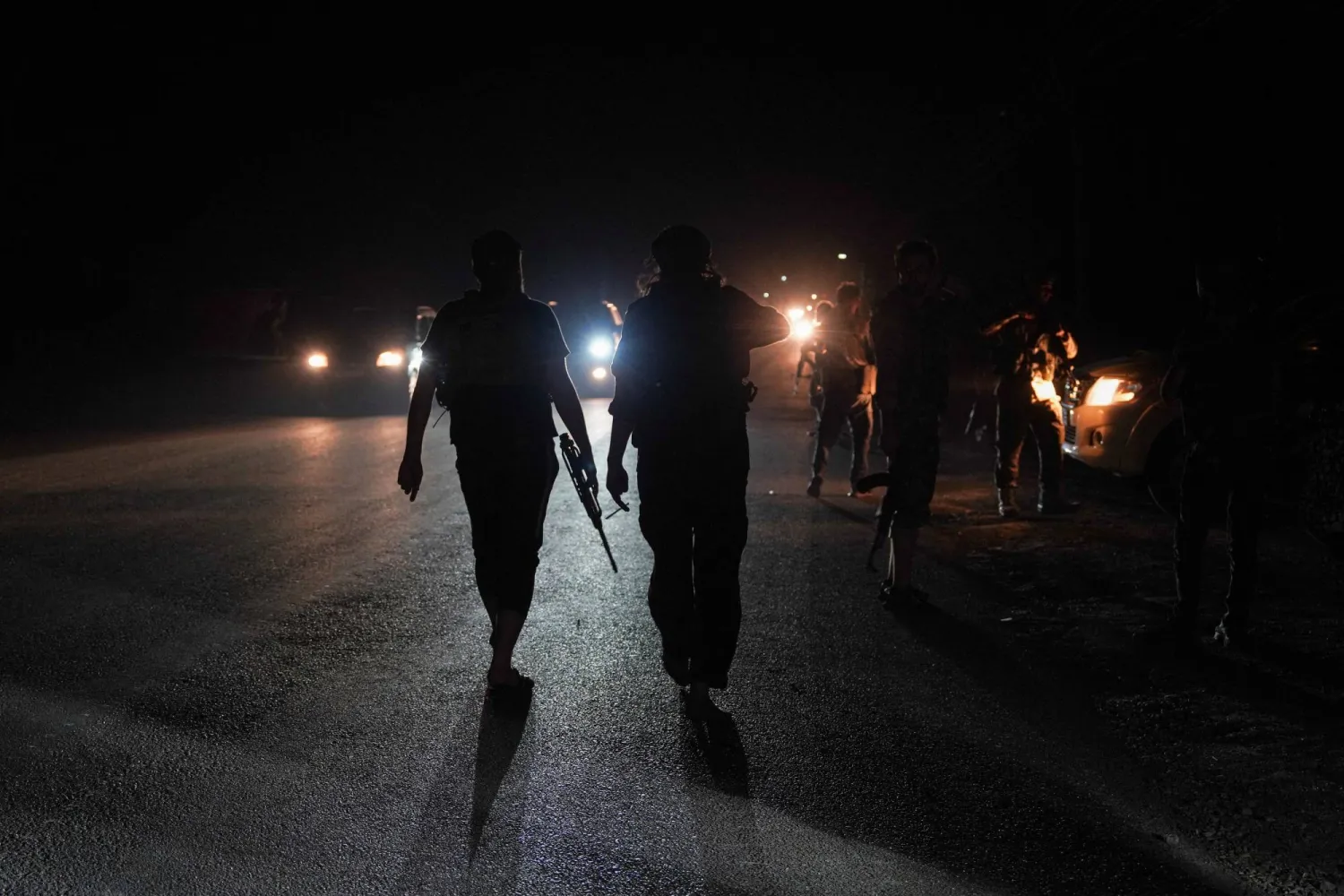 FILE PHOTO: Members of Syrian security forces walk on a road in Sweida countryside, as vehicles transporting other Syrian security forces make their way out of the predominantly Druze city of Sweida, Syria, July 16, 2025. REUTERS/Karam al-Masri/File Photo