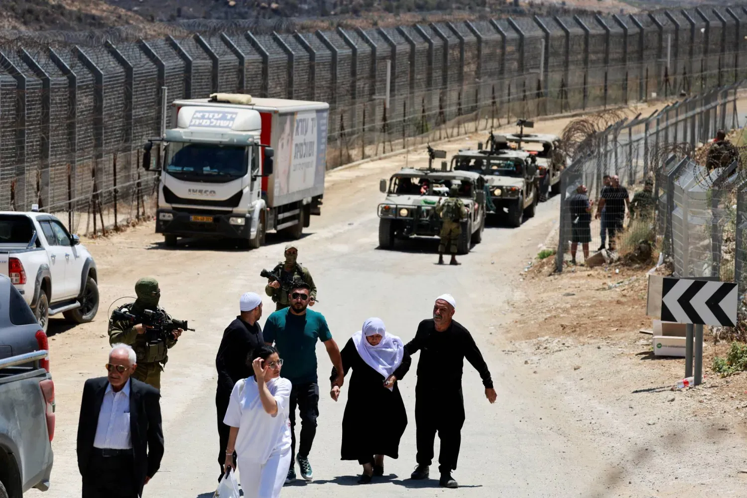 İsrail askerleri ve Dürzi aileler perşembe günü Golan Tepeleri'ndeki Mecdel Şems'tan Suriye'ye dönüyor, (Reuters)
