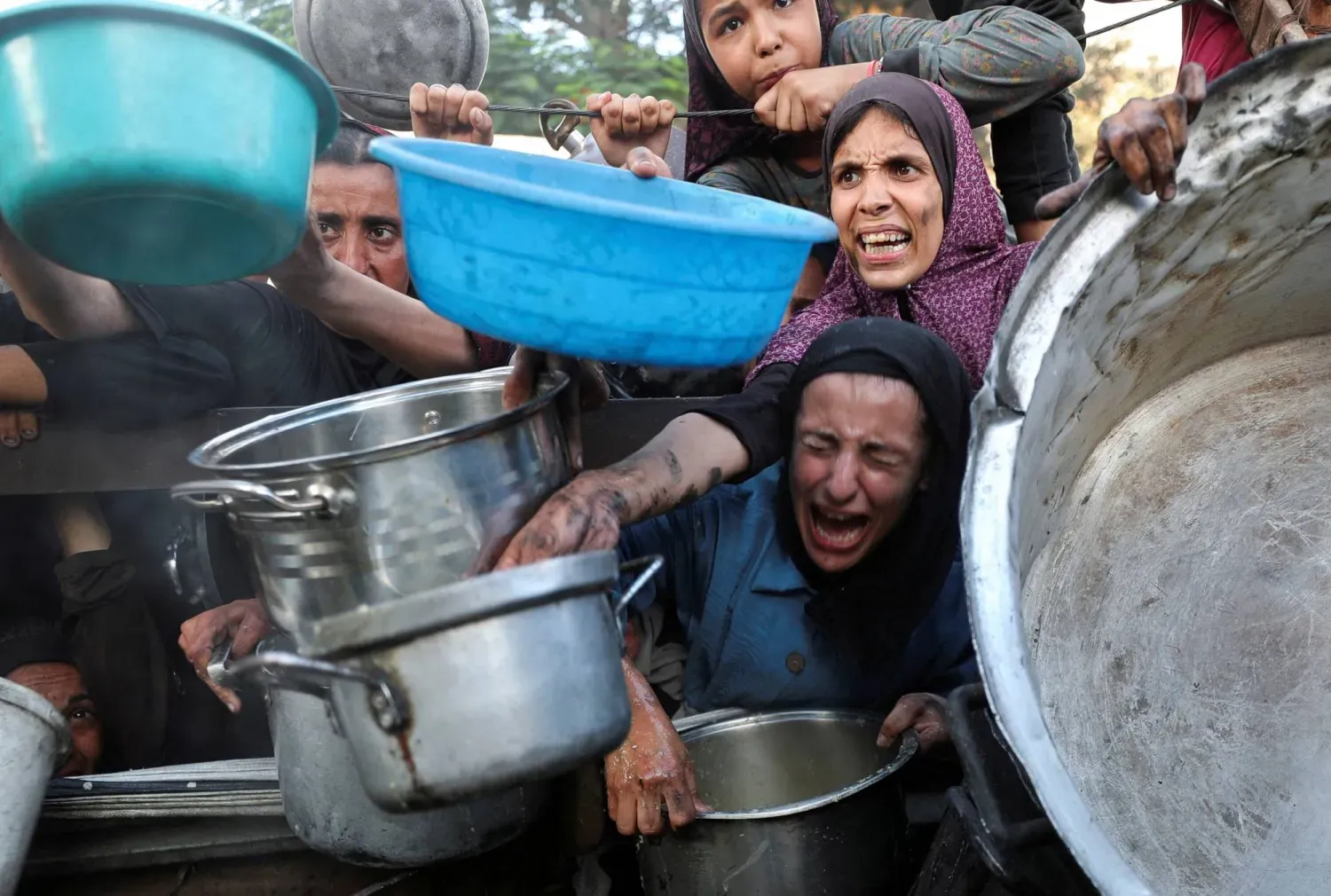 Gazze'deki açlık krizinde Filistinliler yardım kuruluşunun mutfağından yemek almak için çabalıyor (Reuters)