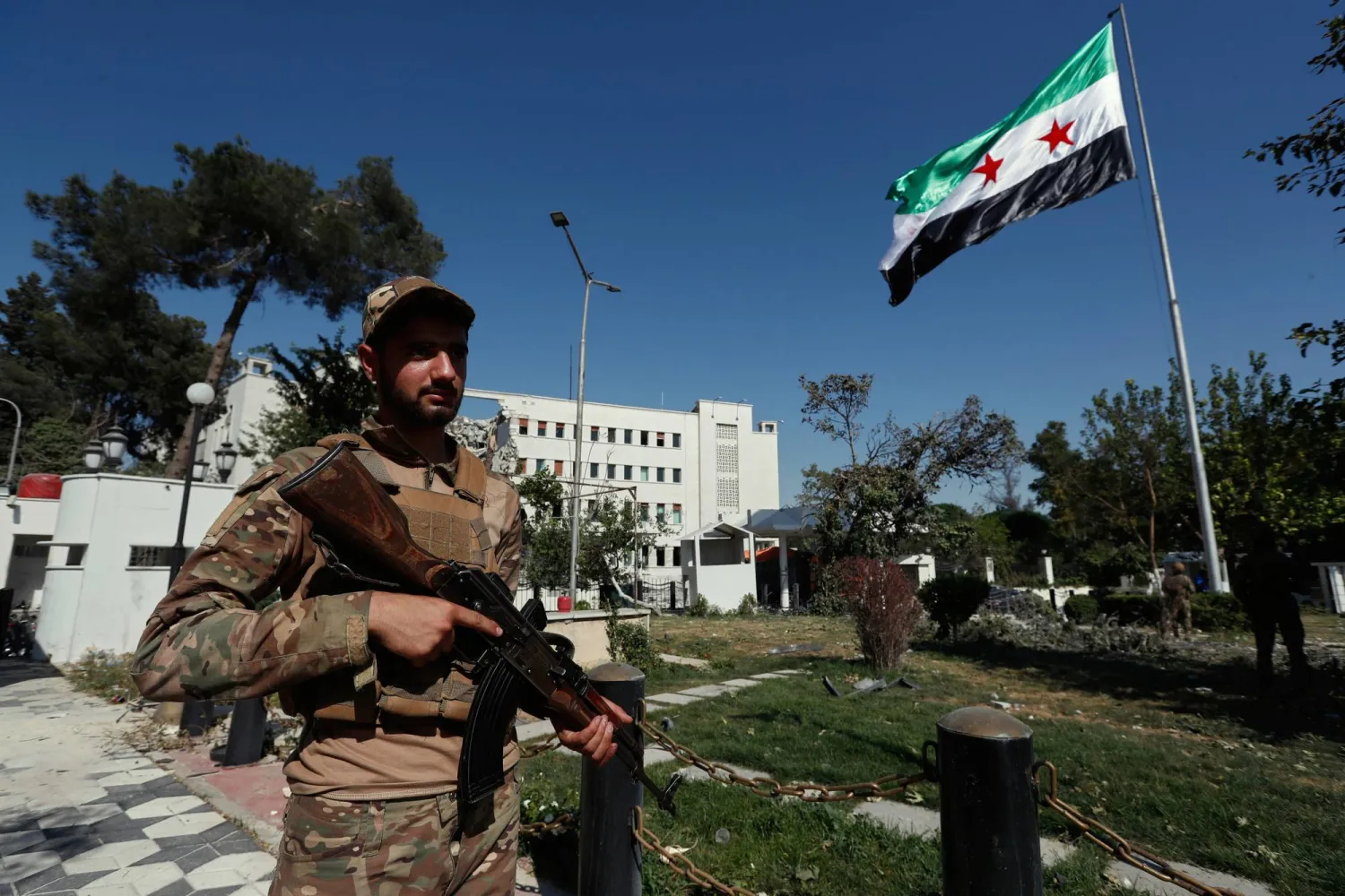 العلم السوري مرفوعاً أمام مبنى وزارة الدفاع في دمشق بعدما تعرض لأضرار بالغة جراء غارات جوية إسرائيلية يوم الأربعاء الماضي (أ.ب)