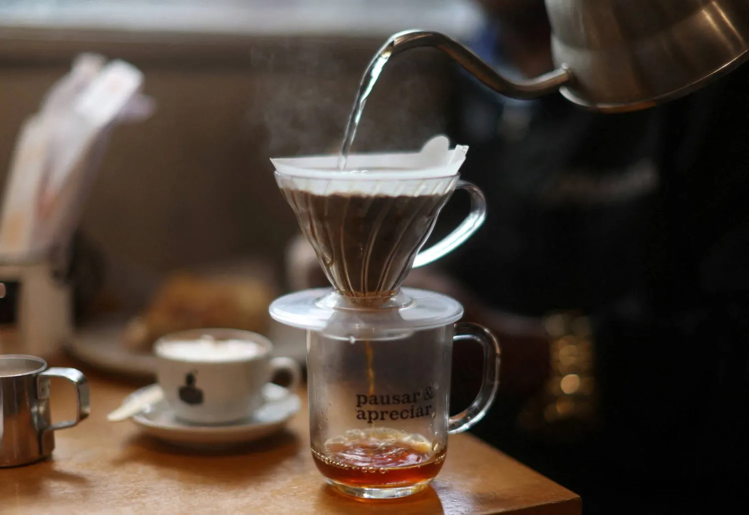 نادلة تقوم بصنع كوب من القهوة في البرازيل (رويترز)