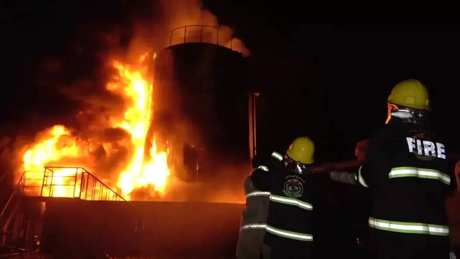رجال إطفاء يحاولون التعامل مع حريق في مصنع إسمنت باجل بعد استهدافه بغارات إسرائيلية (إعلام حوثي)
