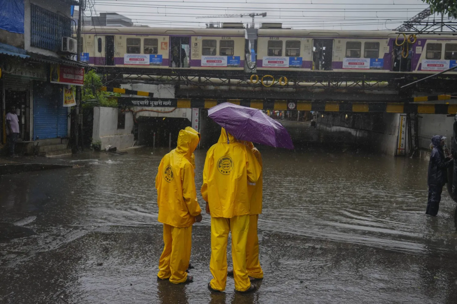 Workers from the Brihanmumbai Municipal Corporation inspect a waterlogged subway during a rain in Mumbai, India, Monday, July 21, 2025. (AP Photo/ Rafiq Maqbool)