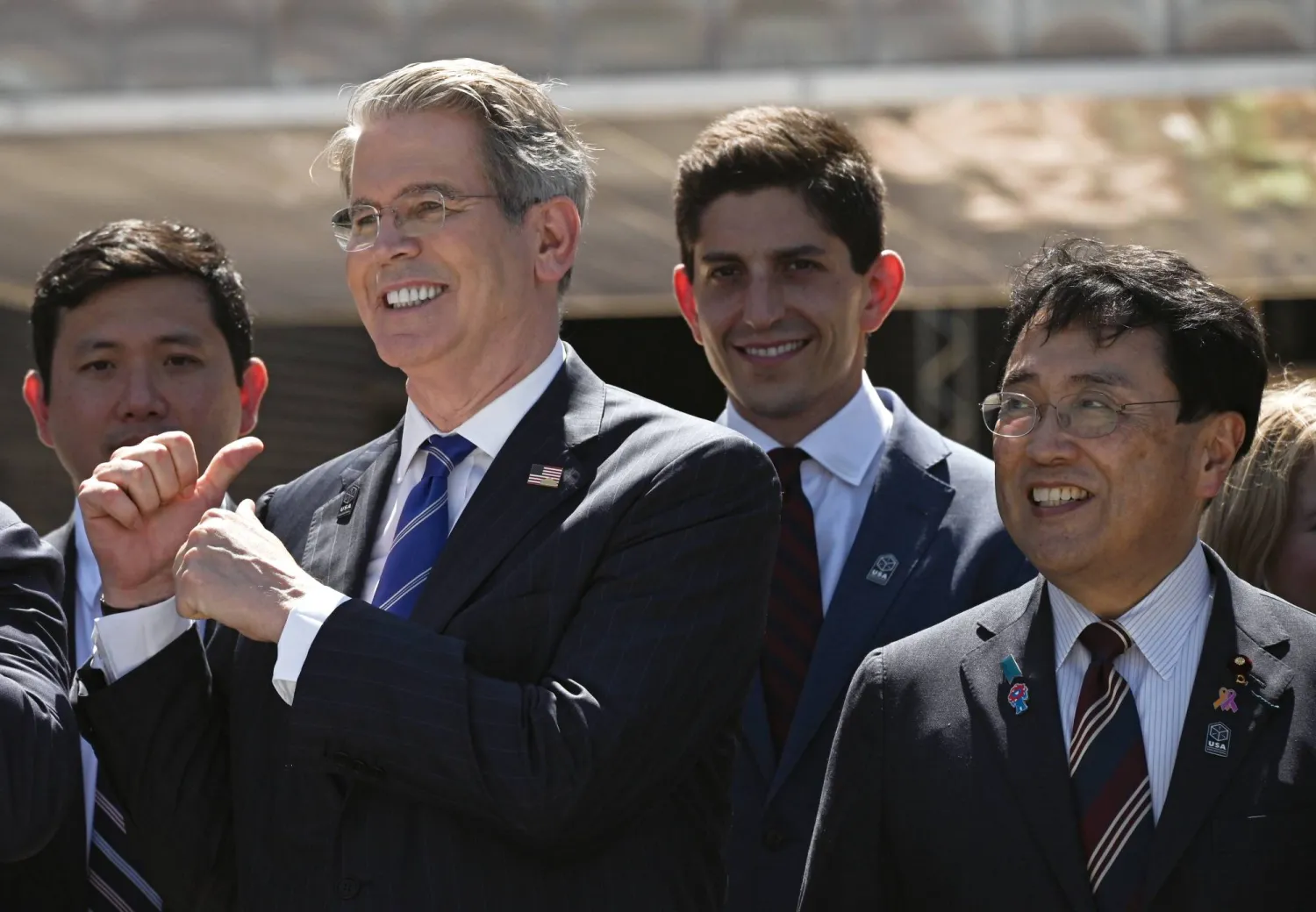 وزير الخزانة سكوت بيسنت يُلوِّح بيده خلال وقوفه مع وزير الإنعاش الاقتصادي الياباني وكبير المفاوضين التجاريين ريوسي أكازاوا في أوساكا (إ.ب.أ)