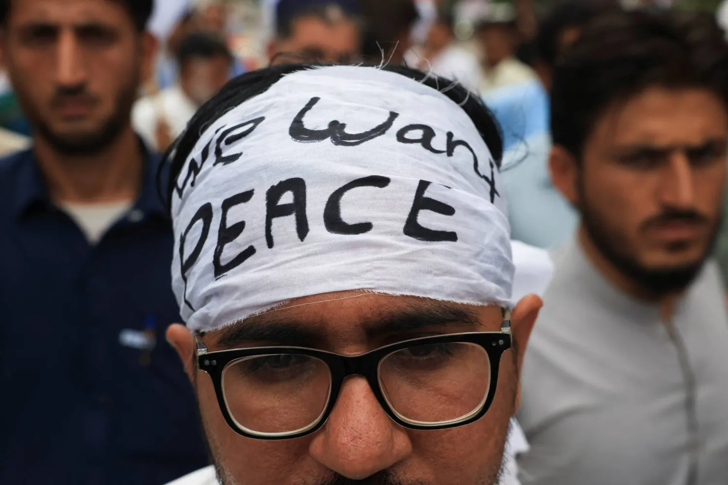 رجل يضع عصابة رأس في حين يشارك مع أشخاص آخرين من باكستان والمناطق القبلية الحدودية في أفغانستان في مظاهرة للاحتجاج على عنف المتشددين والمطالبة باستعادة السلام في كراتشي في 13 يوليو 2025 (رويترز)