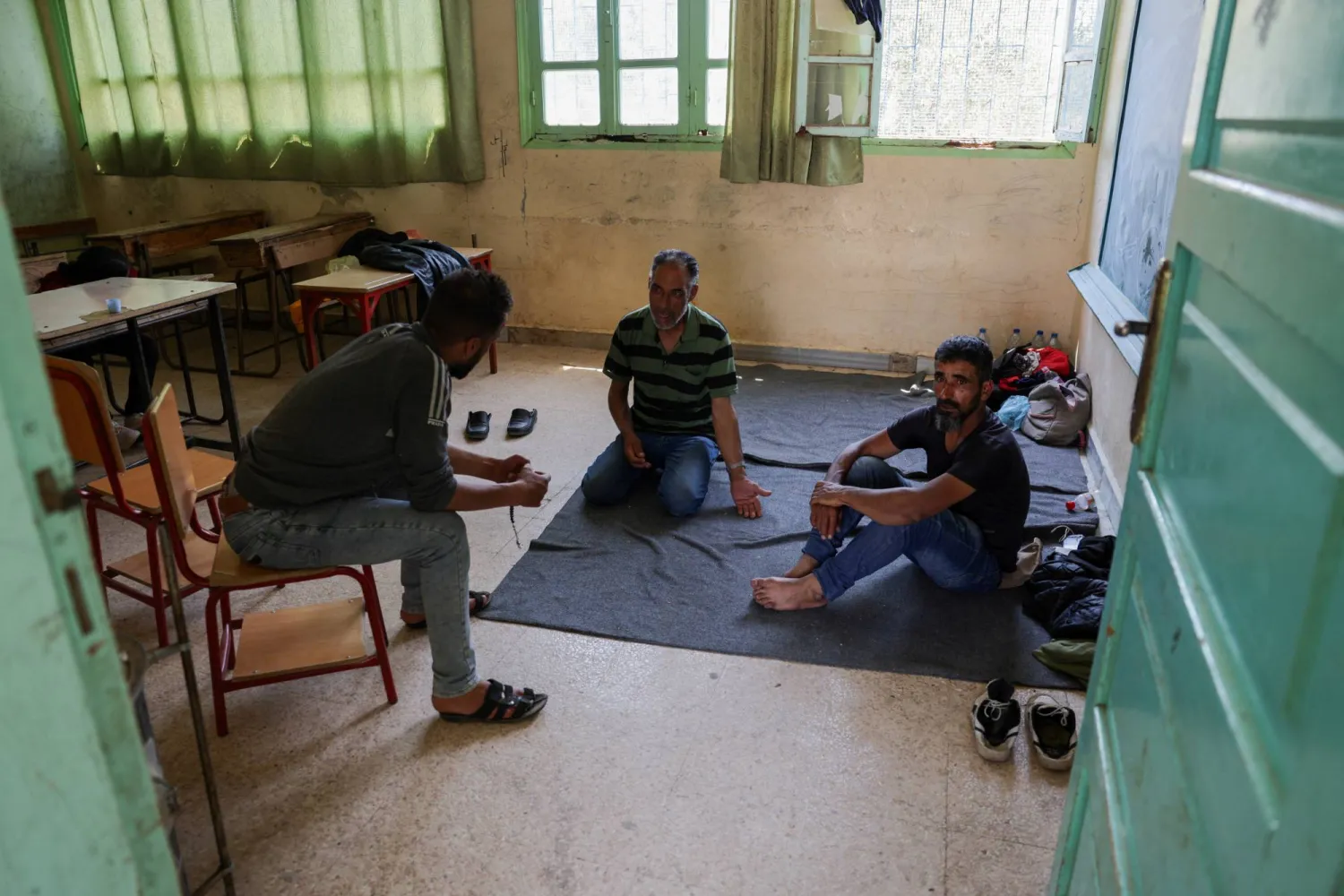 أفراد العائلات البدوية التي غادرت بلدة شهبا في محافظة السويداء جرى إيواؤهم في مدرسة بقرية ناحتة بمحافظة درعا (رويترز)