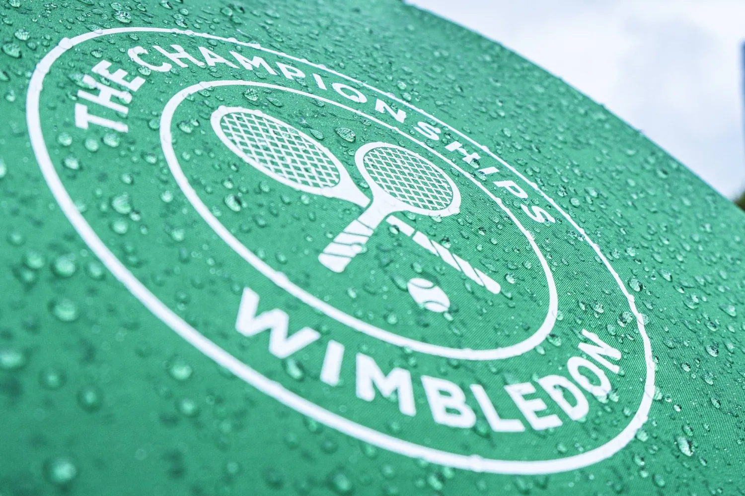 FILED - 29 June 2022, United Kingdom, London: Raindrops and the tournament logo can be seen on an umbrella during the Wimbledon Championships at the All England Lawn Tennis and Croquet Club. Photo: Frank Molter/dpa