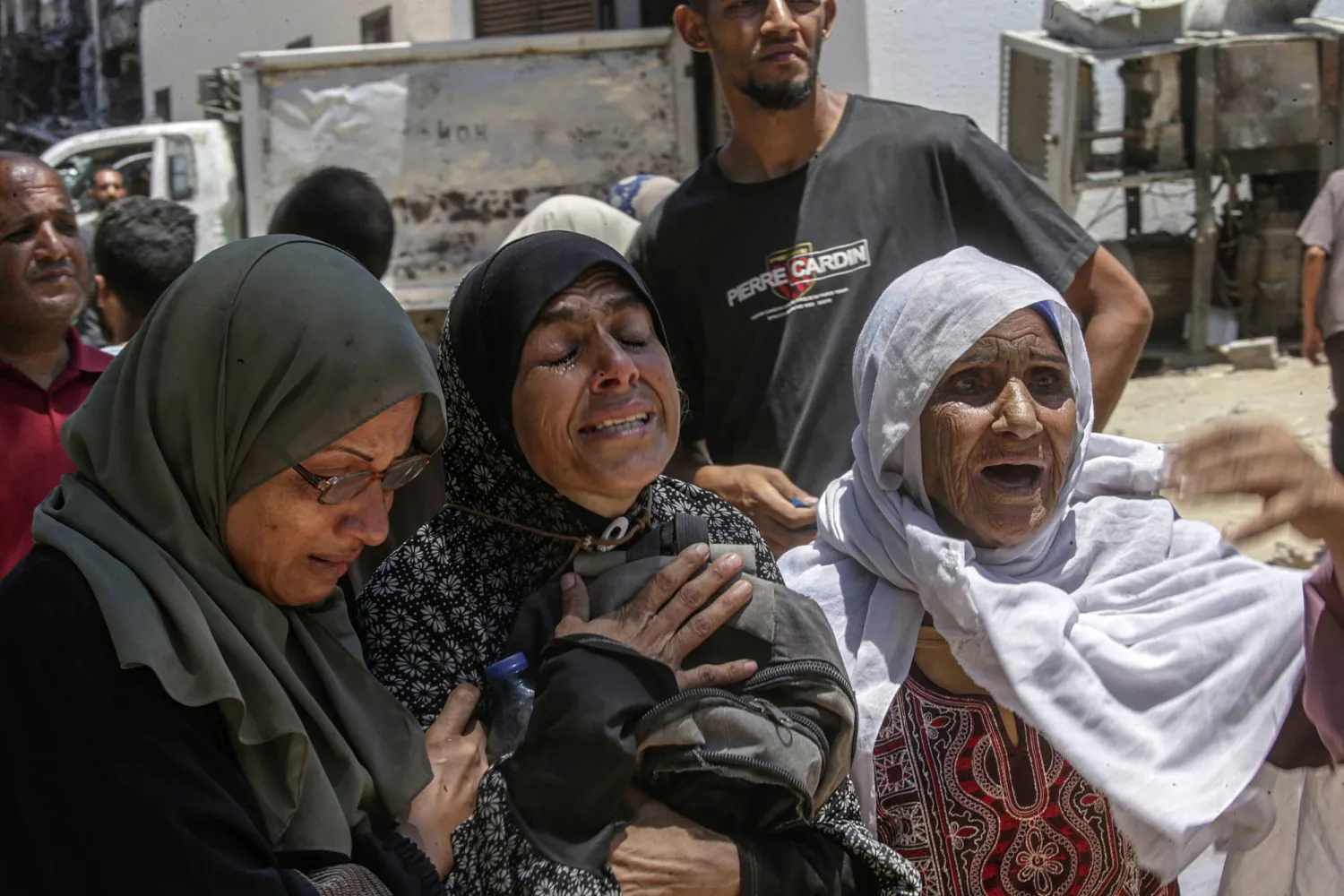 نحيب أم على ابنها بمستشفى الشفاء بمدينة غزة يوم الأحد بعد مقتله بالرصاص عند نقطة توزيع للمساعدات (إ.ب.أ)