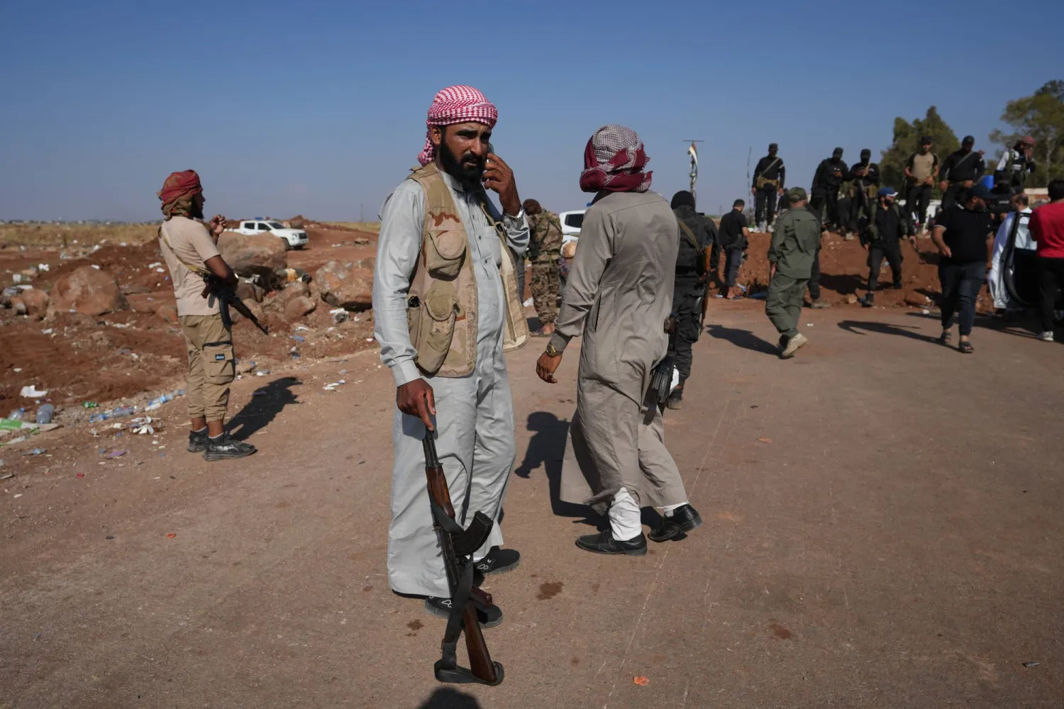 تقف قوات الأمن السورية بالقرب من السواتر الترابية التي أقامتها أمس قرب بلدة بصر الحرير في ريف درعا لمنع القوات العشائرية من التقدم باتجاه القرى الدرزية في محافظة السويداء (د.ب.أ)