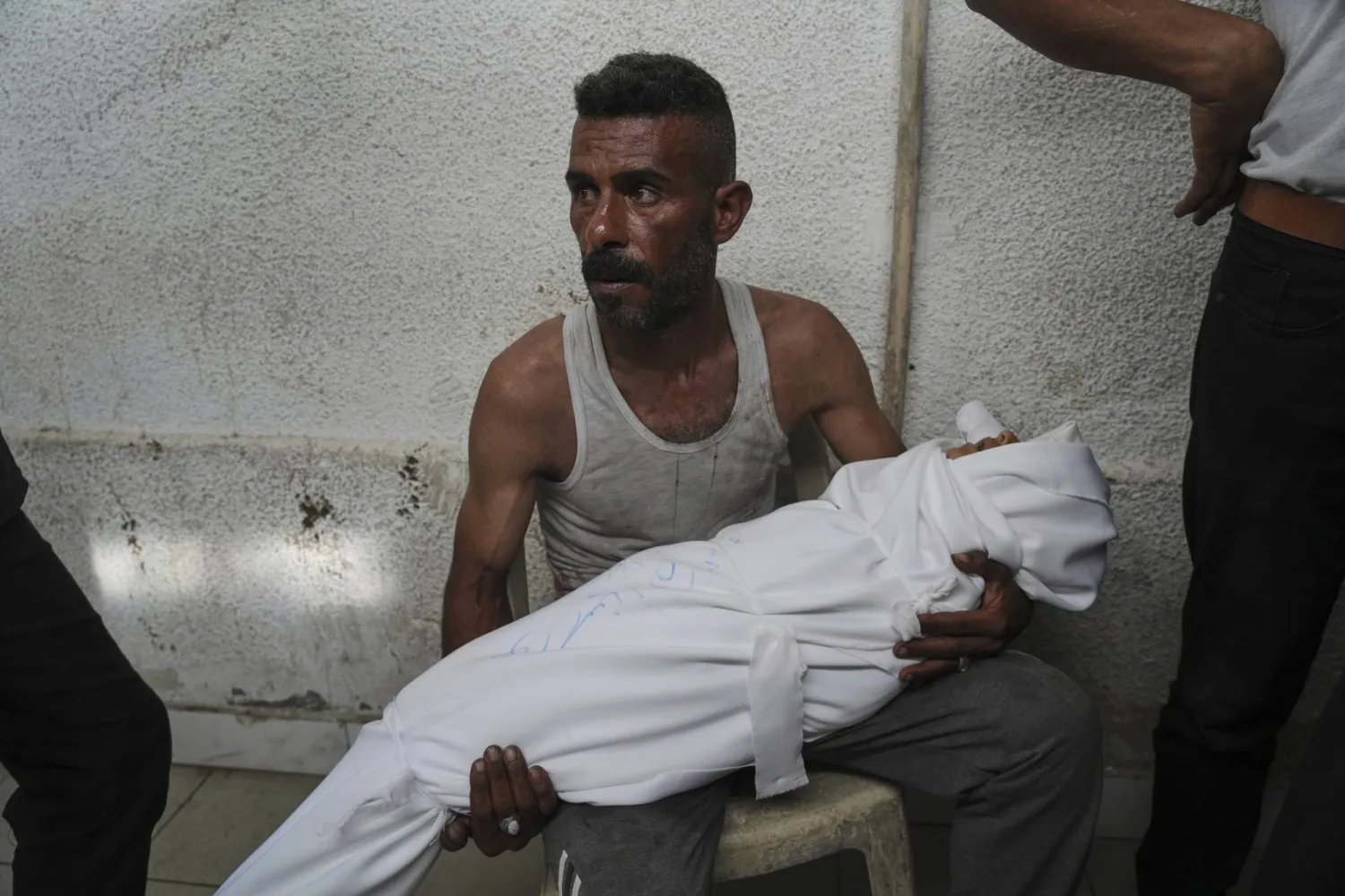 فلسطيني يحمل جثة طفل قُتل بغارة إسرائيلية على مدينة غزة الثلاثاء (أ.ب)