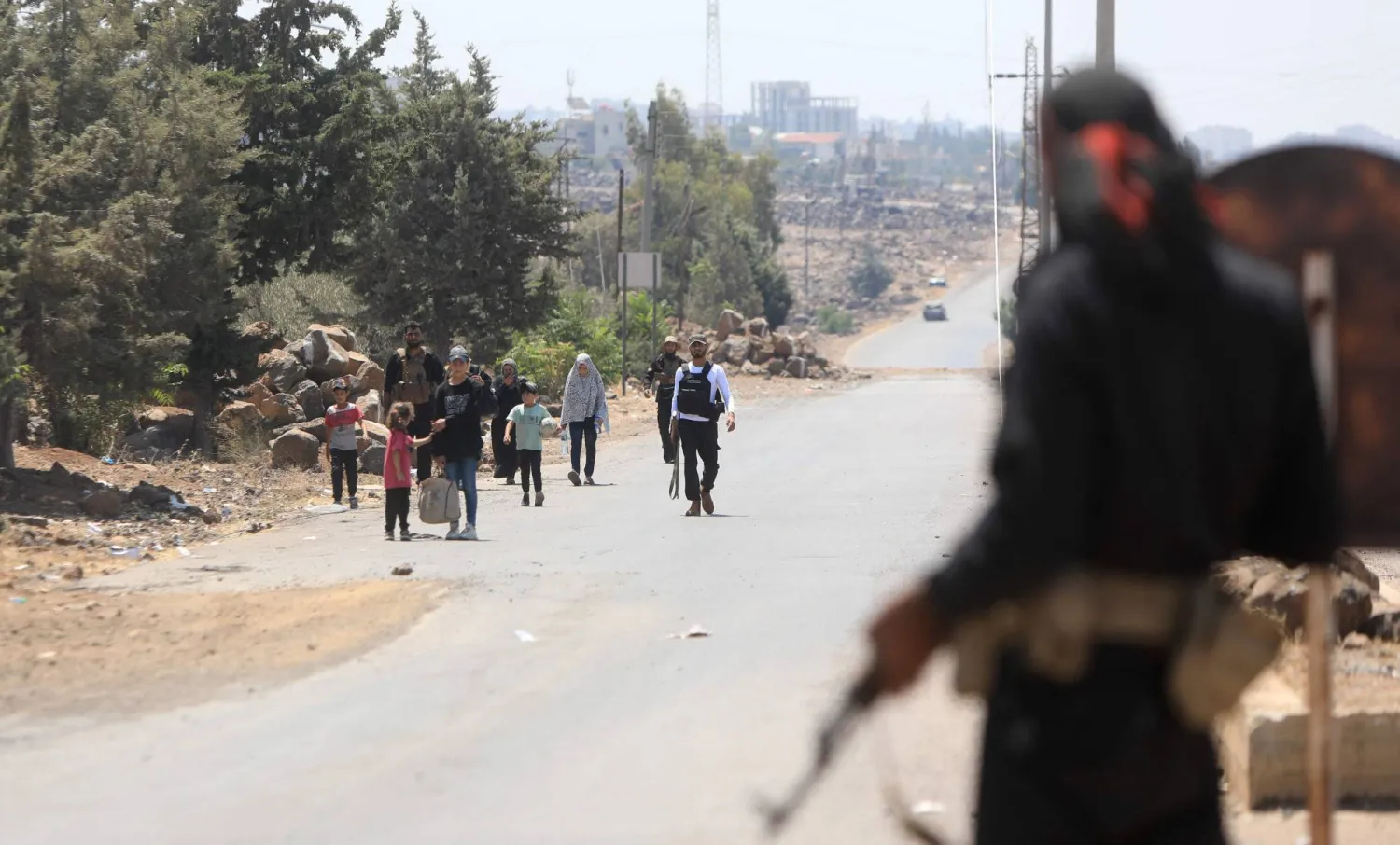 أفراد من القوات السورية يساعدون على إجلاء البدو العرب من السويداء (أ.ف.ب)