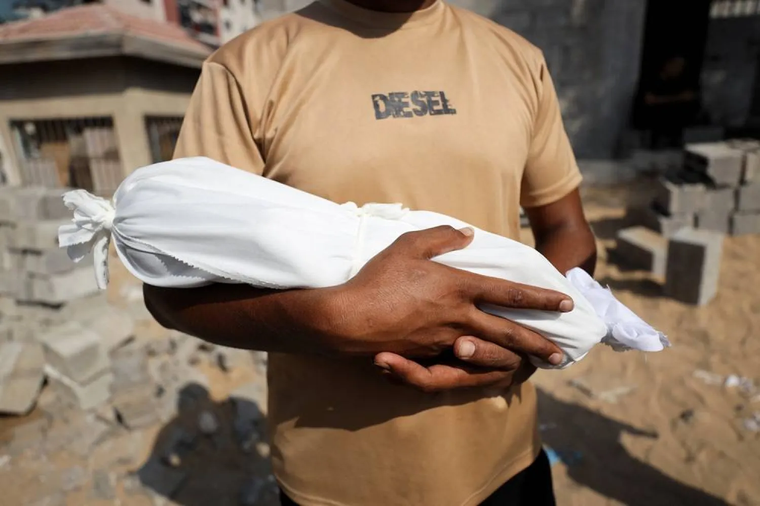  Adham carries the body of his nephew, six-week-old infant Yousef al-Safadi, who died of starvation according to health officials, in Gaza City July 22, 2025. (Reuters)