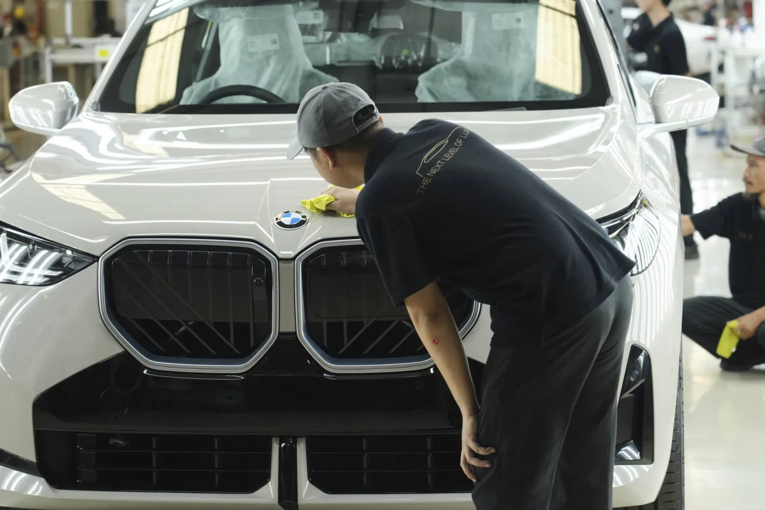 عمال ينظفون سيارة «بي إم دبليو» في شبكة إنتاج «بي إم دبليو-2» بمصنع في جاكرتا (أ.ب)