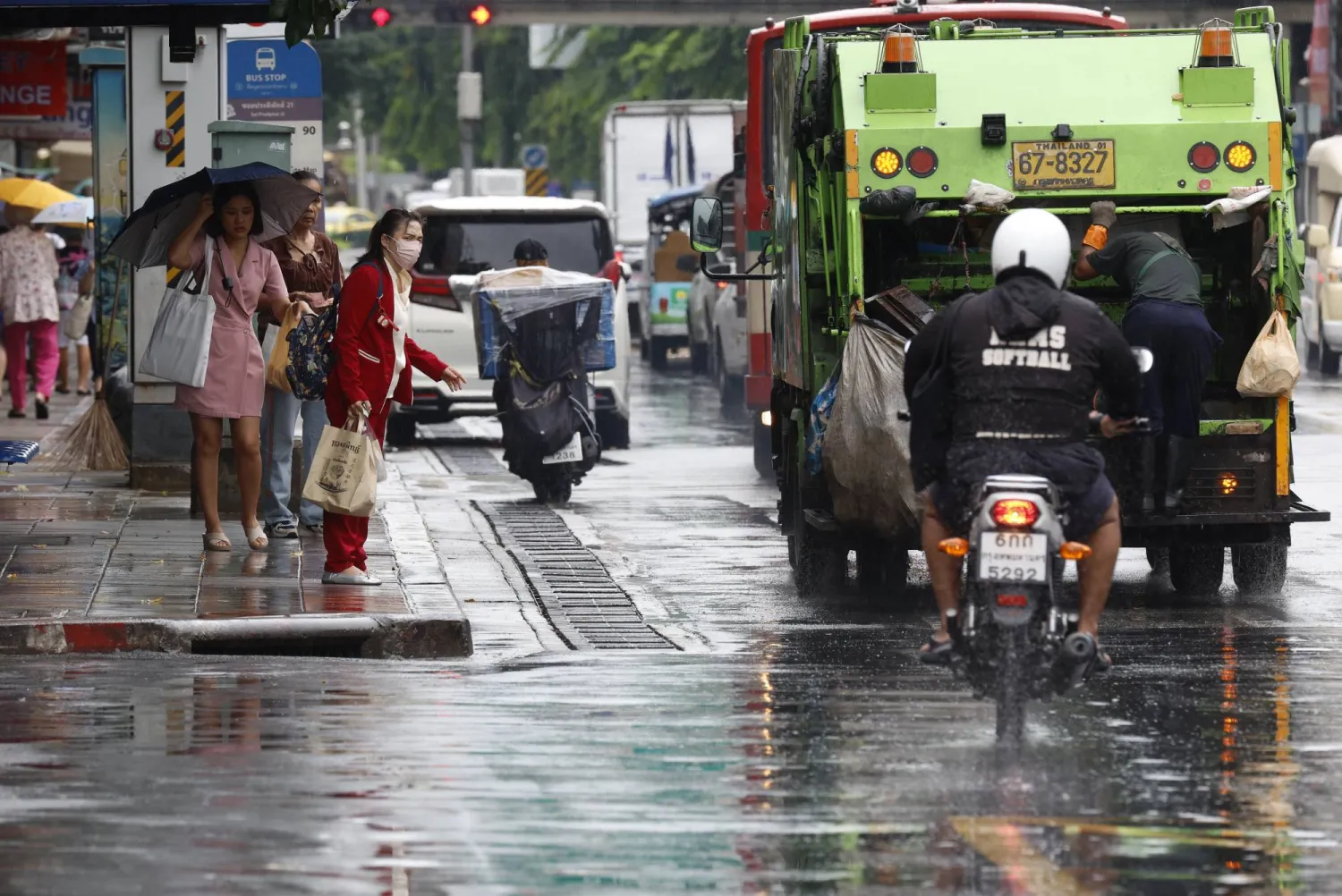 مشاة تحت الأمطار الغزيرة في العاصمة التايلاندية بانكوك (إ.ب.أ)