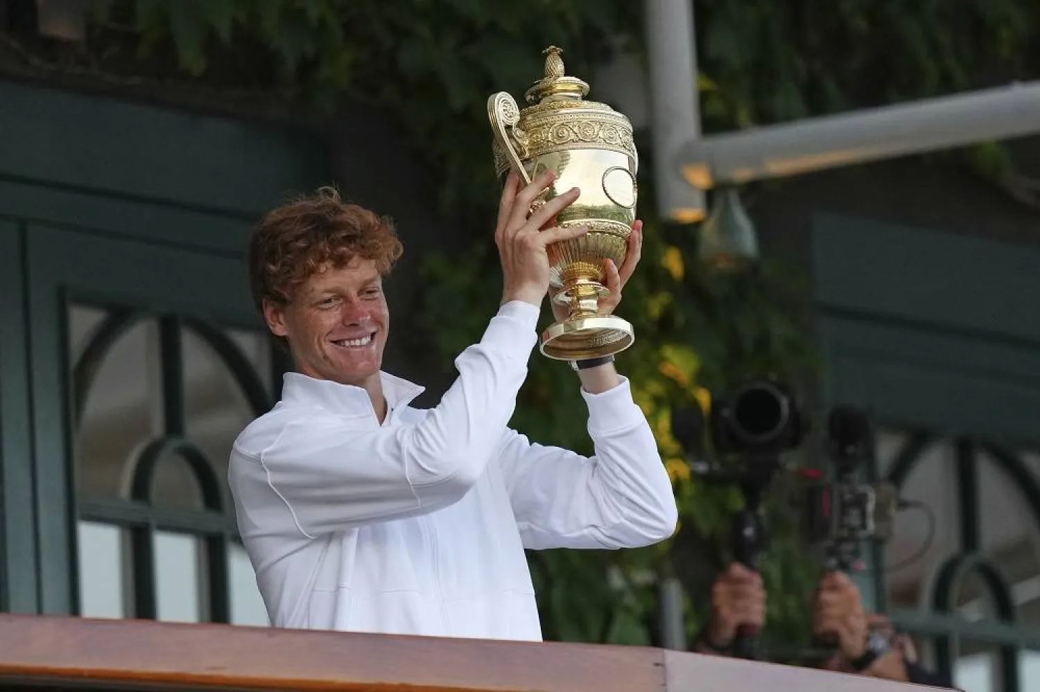 Italy's Jannik Sinner shows the trophy from the balcony of Centre Court after beating Carlos Alcaraz of Spain to win the men's singles final at the Wimbledon Tennis Championships in London, Sunday, July 13, 2025. (AP)