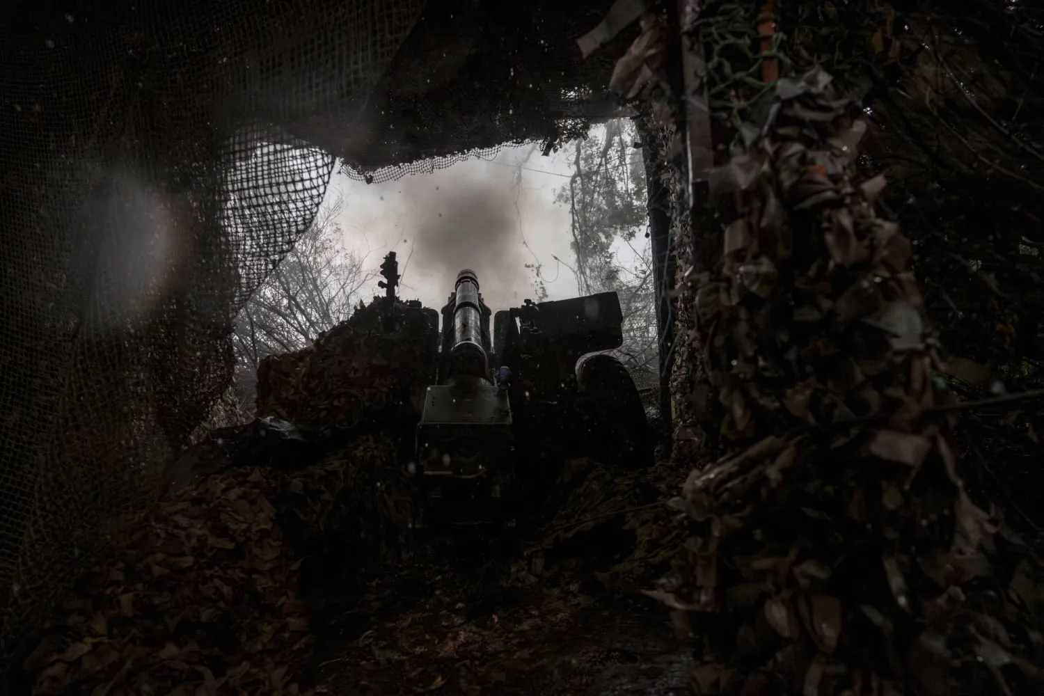 أفراد الخدمة في اللواء العملياتي الثالث عشر «خارتيا» التابع للحرس الوطني الأوكراني يطلقون مدفع هاوتزر من طراز M101 باتجاه القوات الروسية (رويترز)