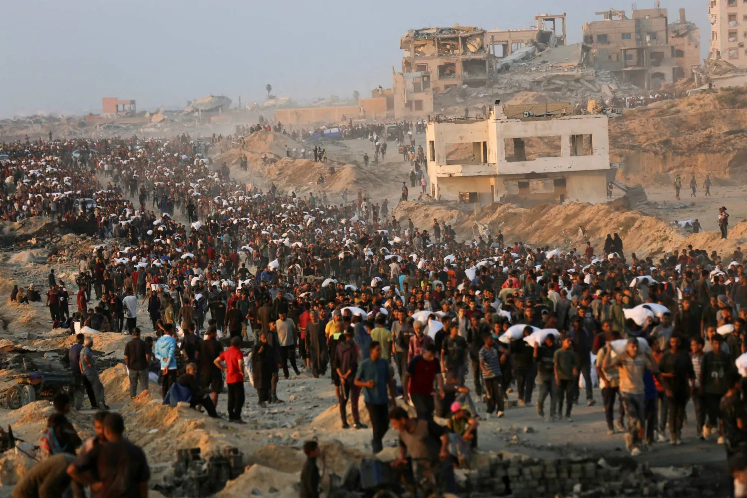 FILE PHOTO: Palestinians gather to receive aid supplies in Beit Lahia, in the northern Gaza Strip, June 17, 2025. REUTERS/Stringer/File Photo