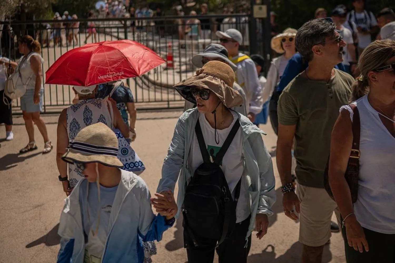 Tourists leave the Acropolis Hill monument site during a heatwave in Athens on July 23, 2025. (AFP)