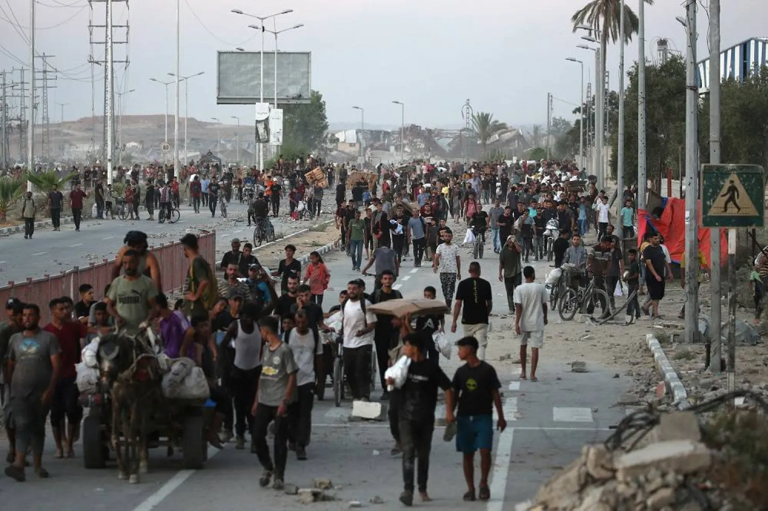 People make their way along al-Rashid street in western Jabalia on July 23, 2025, after receiving humanitarian aid from an aid distribution point in the northern Gaza Strip. (AFP)
