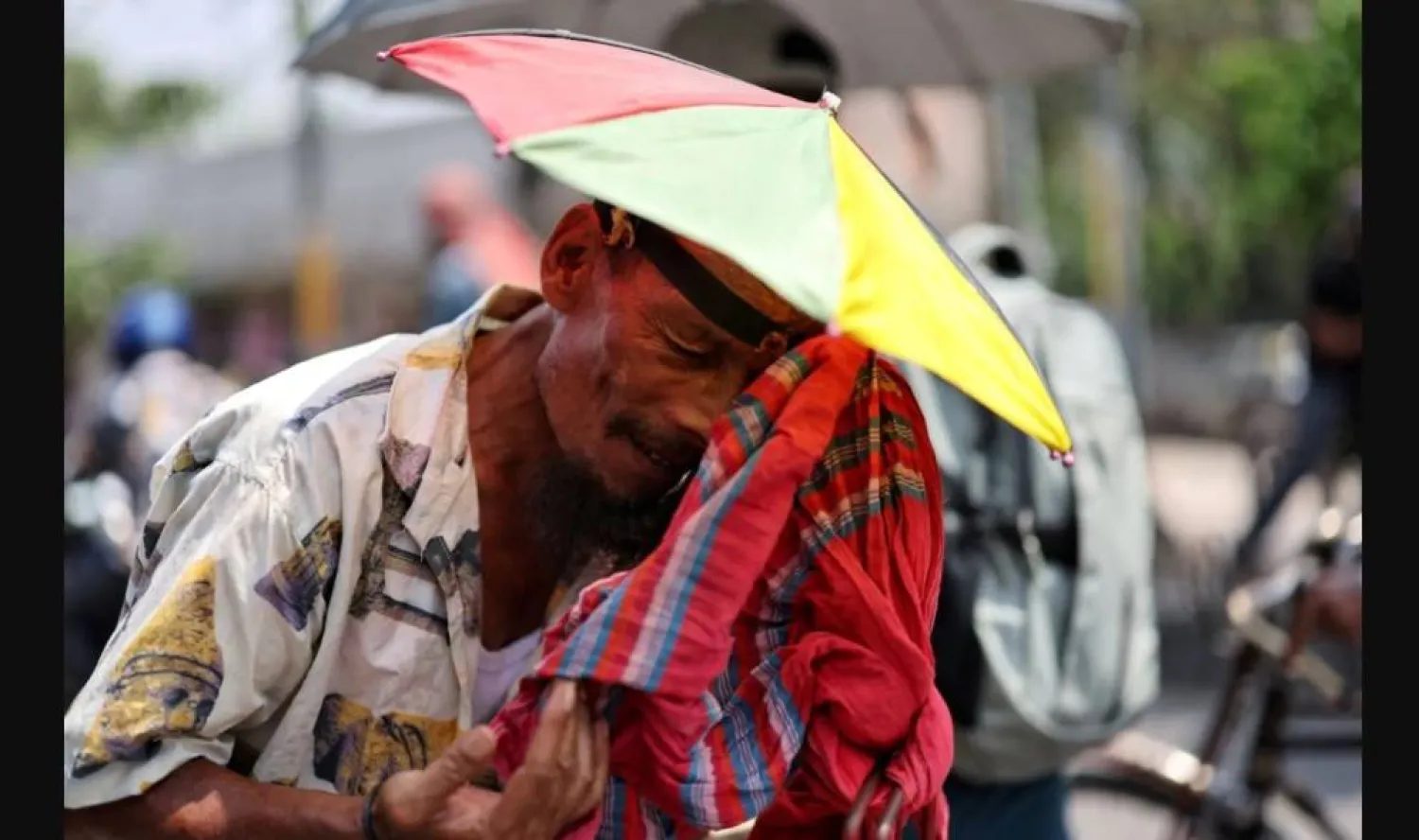 عامل يمسح عرقه خلال موجة حر في بنغلاديش (رويترز)