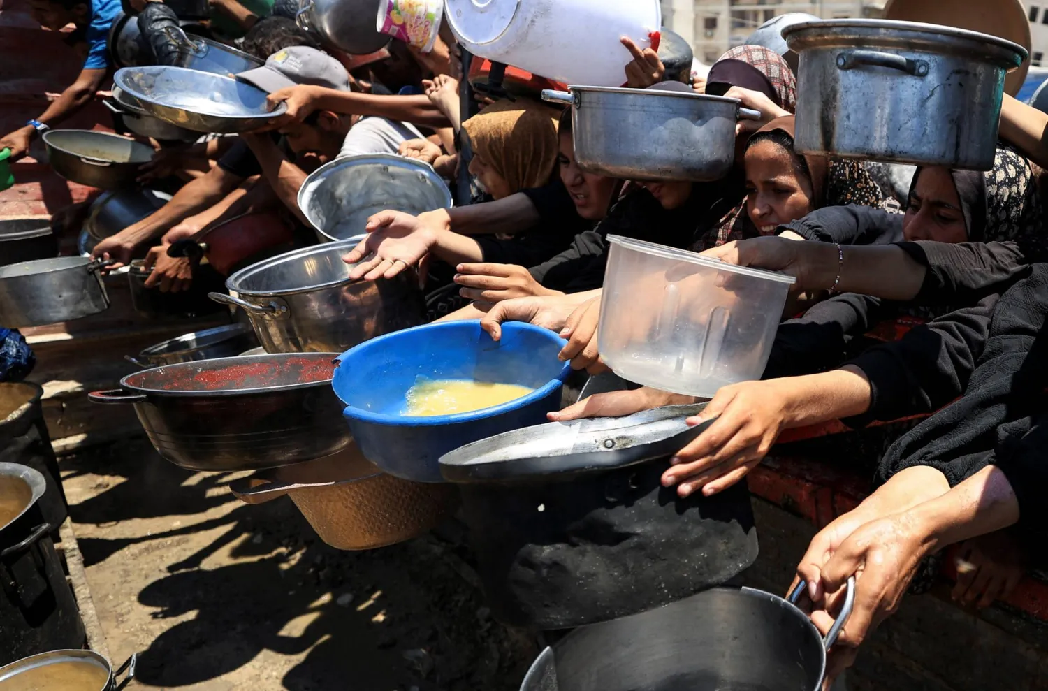 فلسطينيون ينتظرون لتلقي الطعام في قطاع غزة (رويترز)