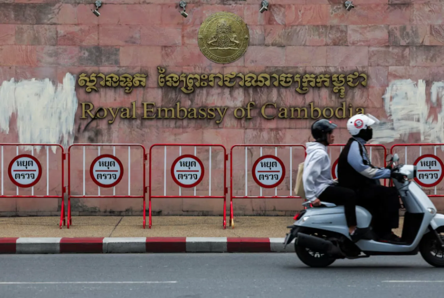 People ride a two-wheeler past the Royal Embassy of Cambodia, after Thailand recalled its ambassador to Cambodia and said it would expel Cambodia's ambassador, following a landmine incident that injured Thai soldiers - Reuters