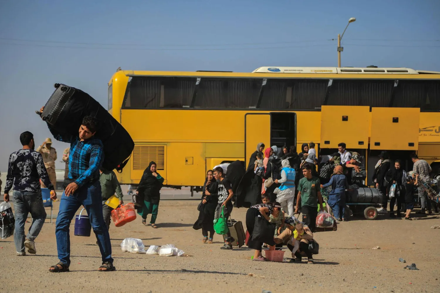 حافلة إيرانية تُنزل لاجئين أفغانيين عند نقطة الصفر على حدود إسلام قلعة بولاية هرات 24 يوليو 2025 (أ.ف.ب)