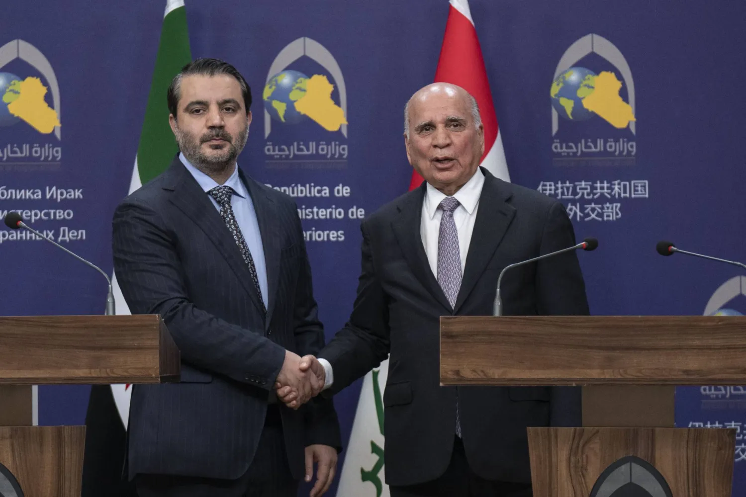 وزير الخارجية العراقي فؤاد حسين (يمين) مصافحاً نظيره السوري أسعد الشيباني في بغداد يوم 14 مارس 2025 (أ.ب)