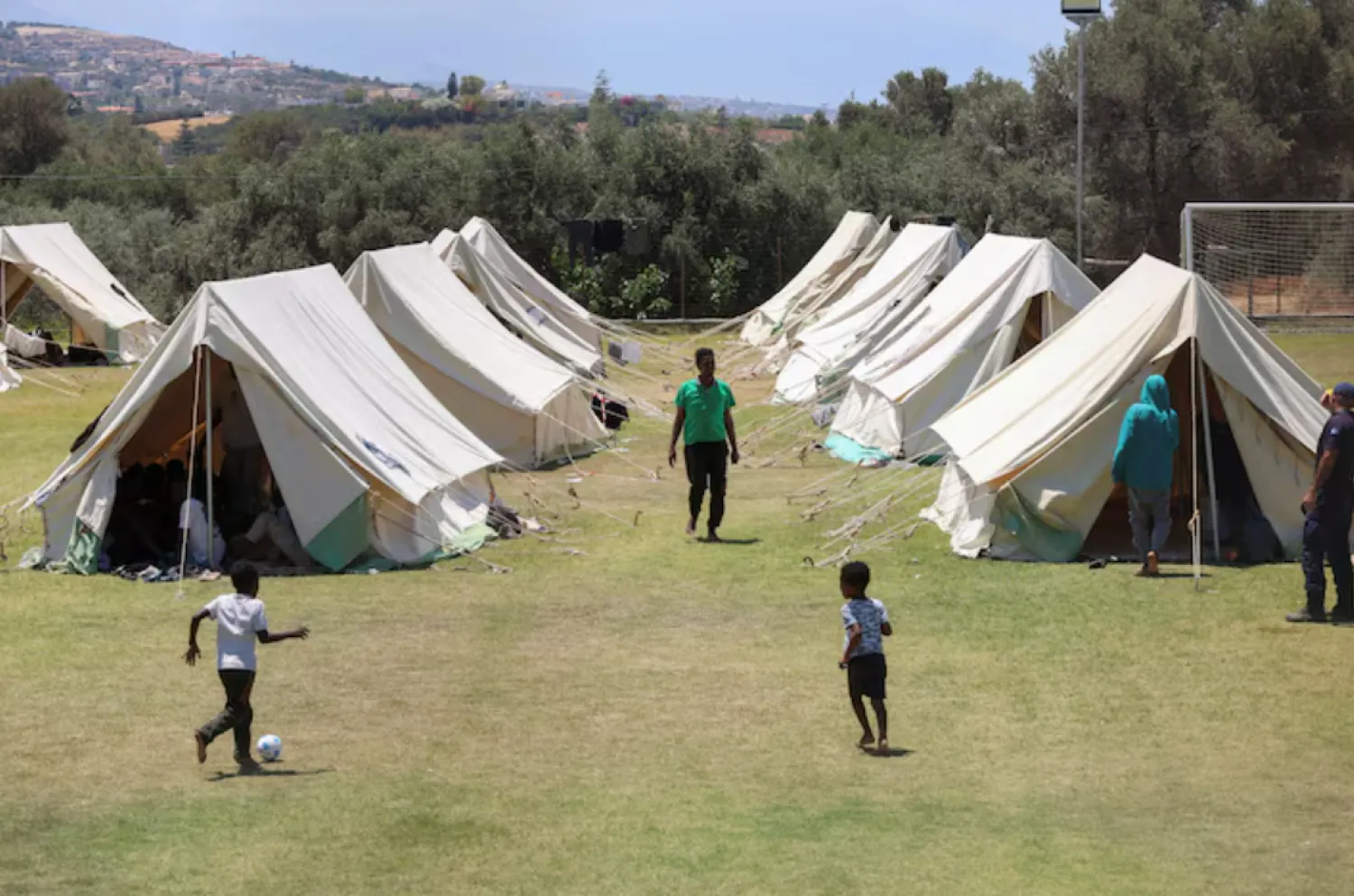 Children play by the tents, as recently arrived migrants shelter at the temporary migrants' camp staged on a soccer pitch in the region of Rethymno in Crete island, Greece, June 24, 2025. REUTERS/Stefanos Rapanis/File Photo