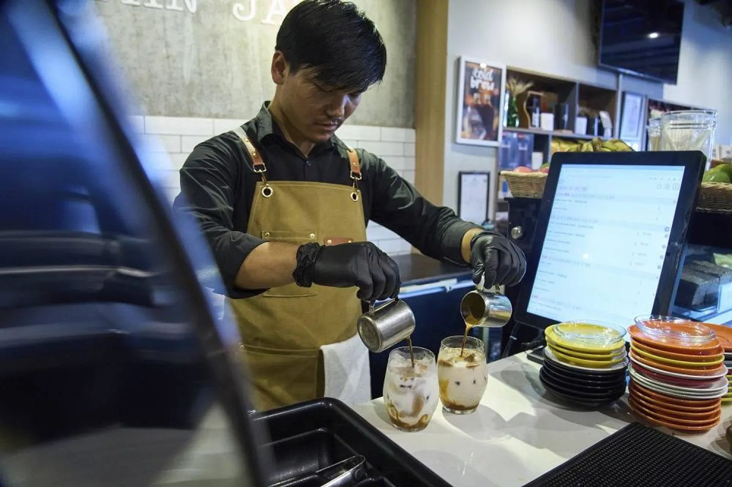An employee prepares a coffee for a customer at Himalayan Java cafe at Boudhanath Stupa in Kathmandu, Nepal, Tuesday, June 10, 2025. (AP)