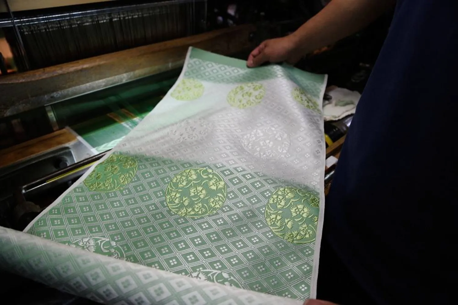 Hironori Fukuoka, the fourth-generation successor to his Nishijinori business, looks at the fabric that is a collaboration with AI in Kyoto, western Japan on July 3, 2025. (AP)