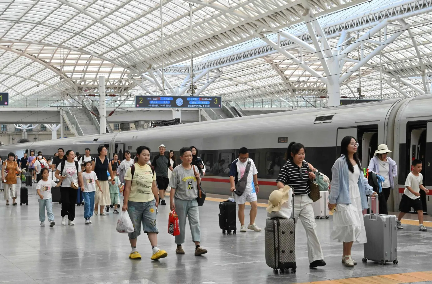 ركاب في محطة قوانغداو للقطارات السريعة بالصين (أ.ف.ب)