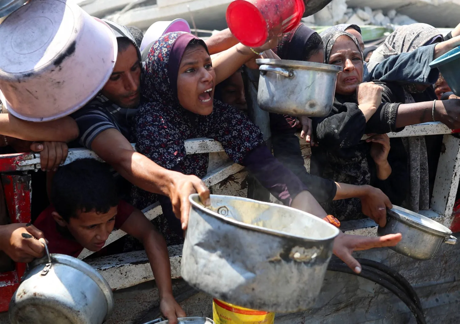 Palestinians wait to receive food from a charity kitchen, amid a hunger crisis, in Gaza City, July 23, 2025. REUTERS/Mahmoud Issa