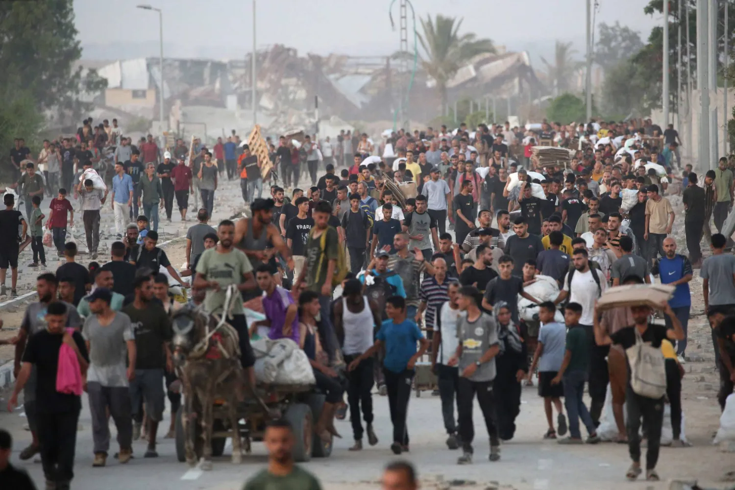فلسطينيون يسيرون في شارع الرشيد غرب جباليا في 23 يوليو بعد تسلمهم مساعدات إنسانية من نقطة توزيع مساعدات في شمال قطاع غزة (أ.ف.ب)