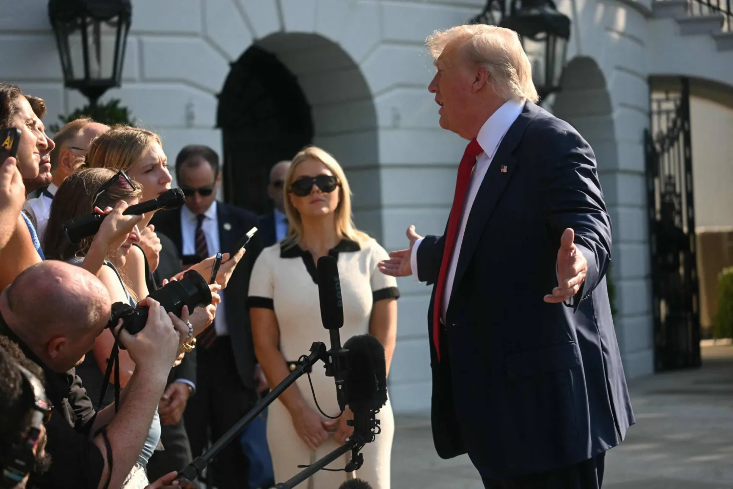 الرئيس الأميركي دونالد ترمب وبجواره كارولين ليفيت المتحدثة باسم البيت الأبيض خلال حديث للصحافيين بواشنطن (أ.ف.ب)