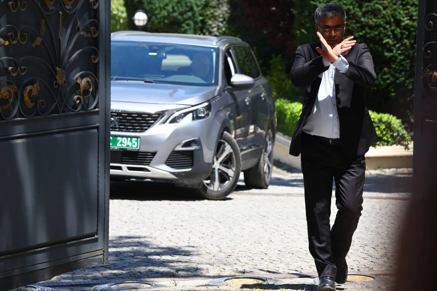 موظف يُشير بيده أثناء مغادرة وفد أوروبي القنصلية الإيرانية عقب محادثات نووية بإسطنبول في 25 يوليو 2025 (إ.ب.أ)