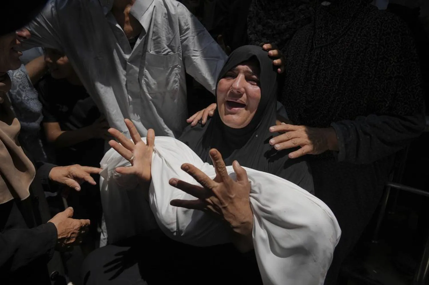  Relatives mourn over the body of 11-year-old Palestinian boy Qais Adwan, who was killed in an Israeli airstrike on a school in Gaza that has been used as a shelter, during his burial at Al Shifa Hospital in Gaza City, Friday, July 25, 2025. (AP) 