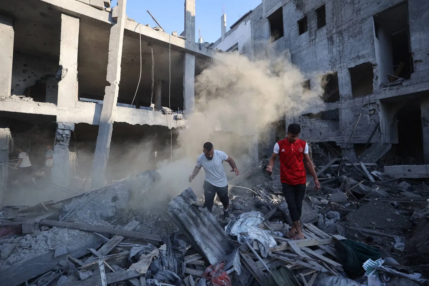 فلسطينيون يتفقدون الأضرار التي لحقت بمخيم البريج للاجئين في وسط قطاع غزة (أ.ف.ب)