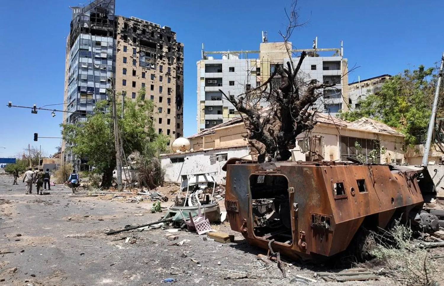Members of army walks near a destroyed military vehicle and bombed buildings, as Sudan's army retakes ground and some displaced residents return to ravaged capital in the state of Khartoum Sudan March 26, 2025. (Reuters)