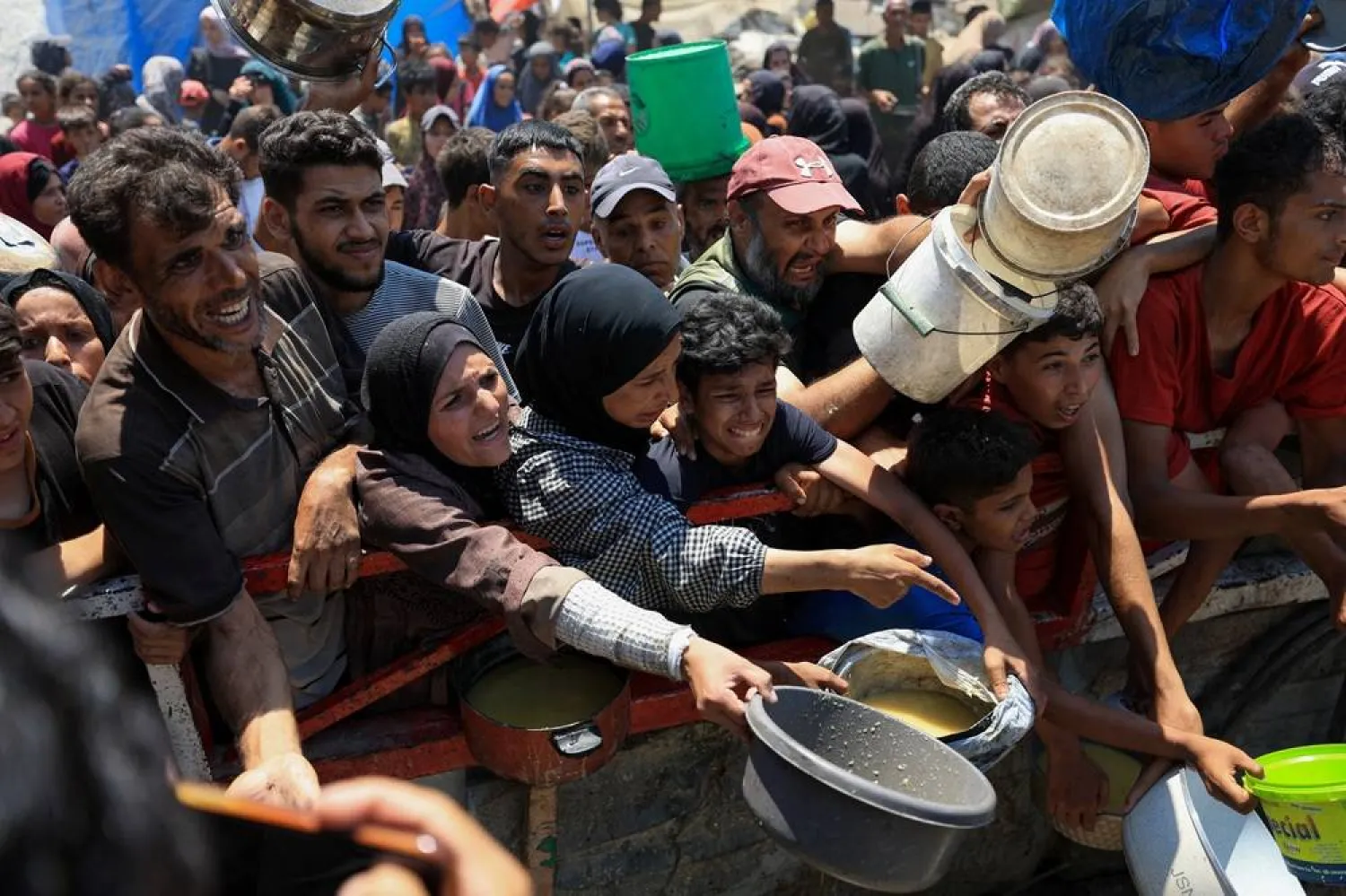  Palestinians gather to receive food from a charity kitchen, amid a hunger crisis, in Gaza City, July 25, 2025. (Reuters)