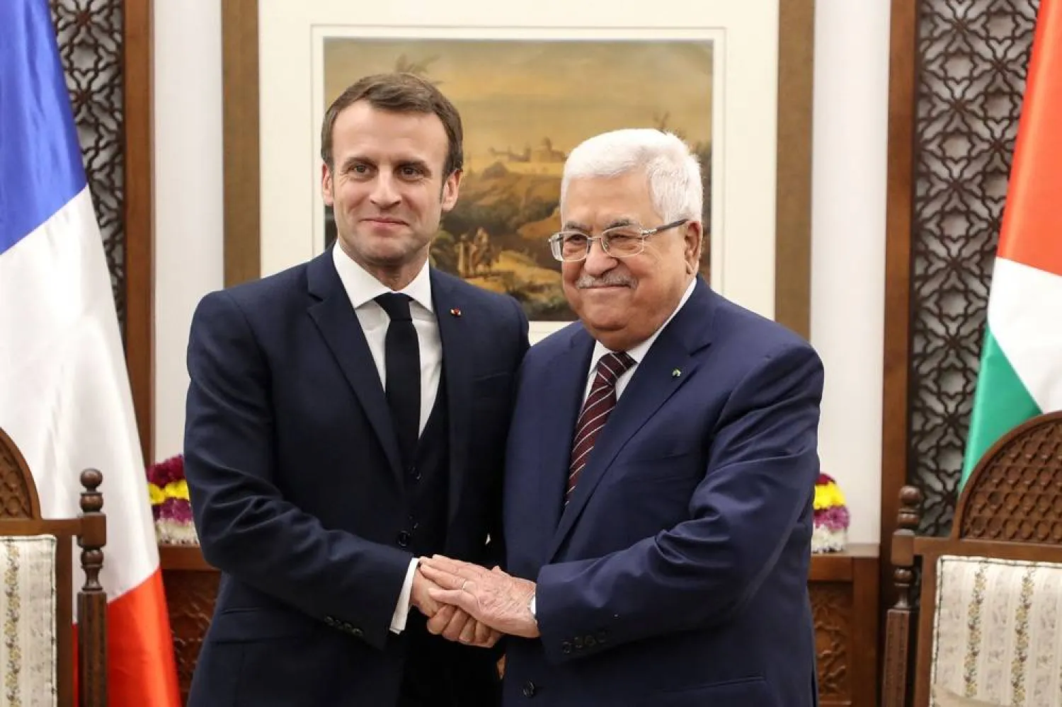 French President Emmanuel Macron (L) shakes hands with Palestinian President Mahmoud Abbas at his headquarters in the West Bank city of Ramallah, on January 22, 2020. (AFP) 