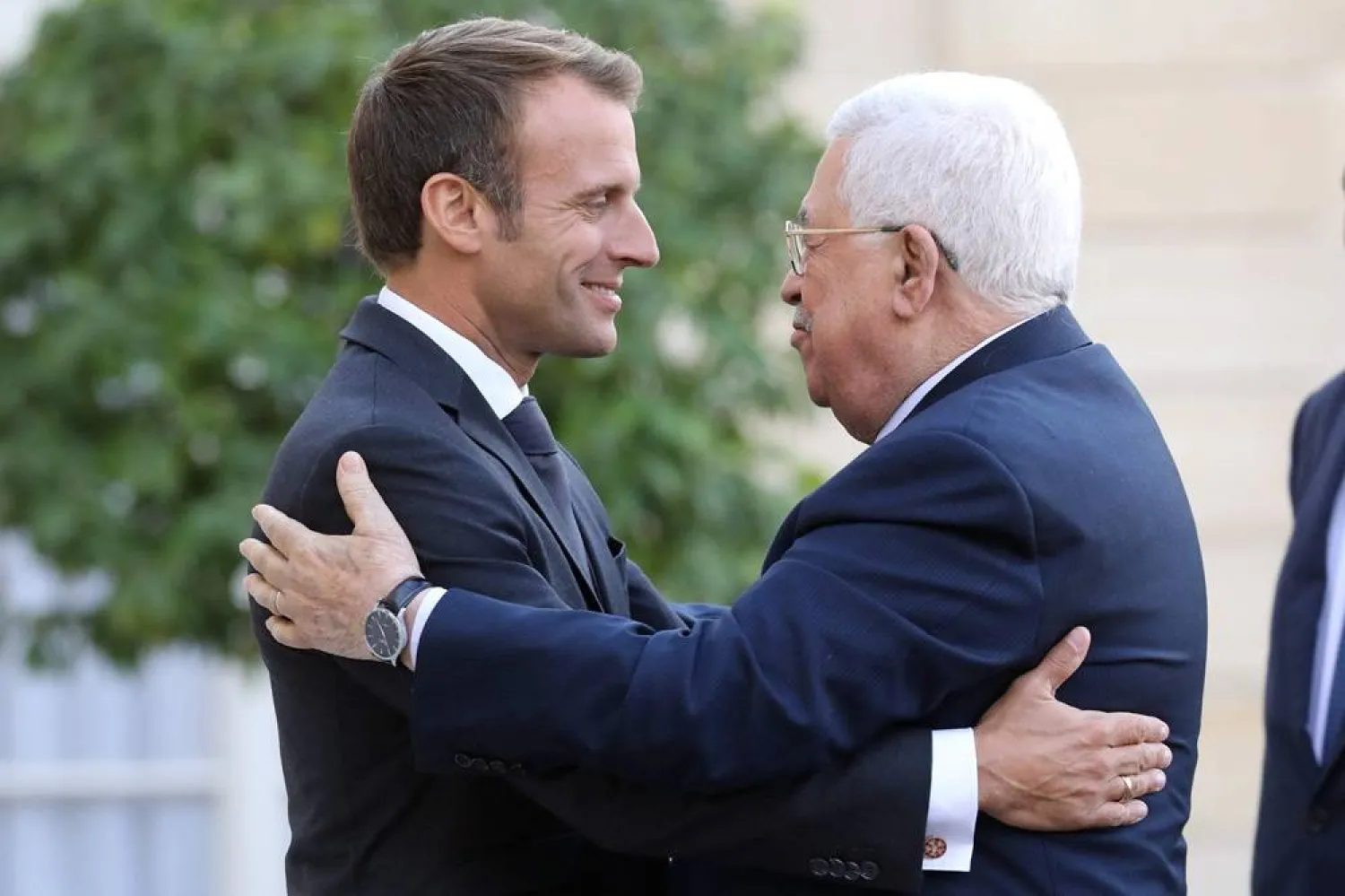 French President Emmanuel Macron (L) welcomes Palestinian President Mahmoud Abbas prior to their meeting at the Elysee Palace, on September 21, 2018 in Paris. (AFP)