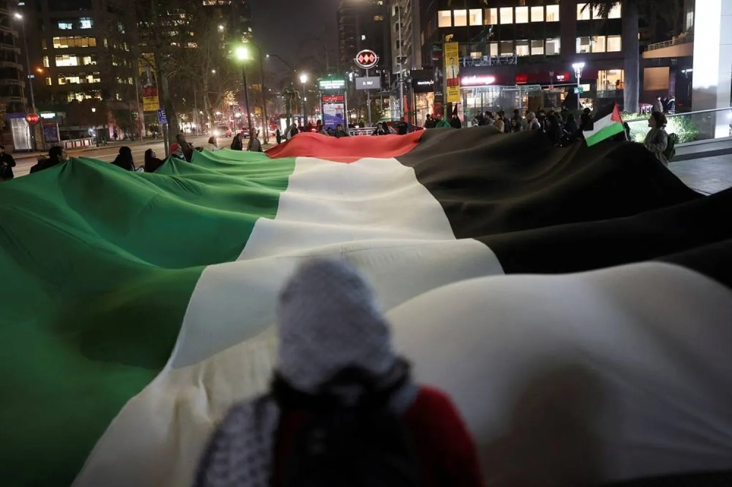  Protesters hold a Palestinian flag during a protest in solidarity with Palestinians in Gaza, in Santiago, Chile July 25, 2025. (Reuters)