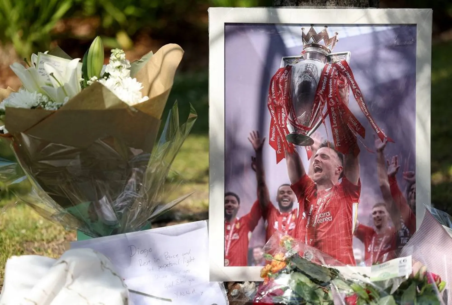 A picture of Liverpool's Portuguese soccer player Diogo Jota stands next to flower tributes, after Jota died in a car crash near Zamora, Spain, outside Anfield Stadium in Liverpool, Britain, July 3, 2025. (Reuters)