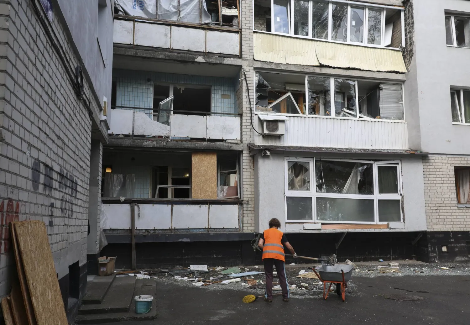 عامل يزيل الأنقاض في موقع القصف على منطقة سكنية في خاركيف بشمال أوكرانيا (إ.ب.أ)