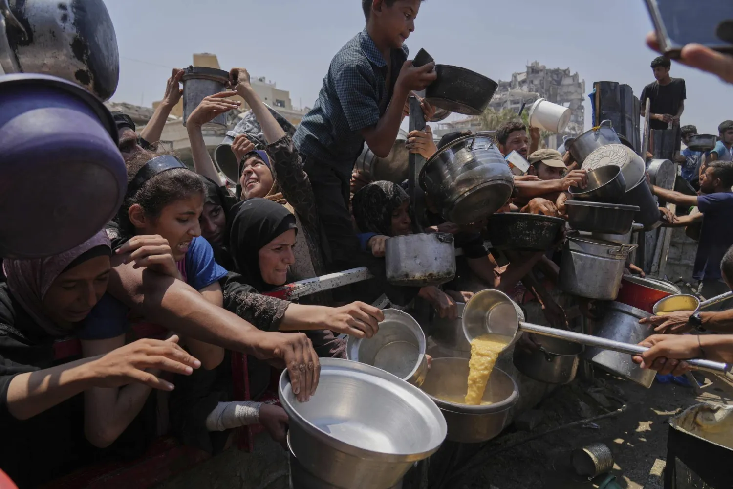 فلسطينيون يكافحون للحصول على الطعام المتبرع به في تكية شمال القطاع مدينة غزة (أ.ب)