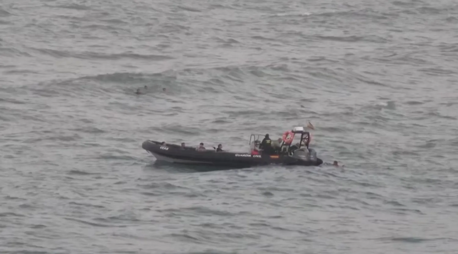 A view shows migrants reaching a police boat, while other group of migrants swim in the background, as at least 54 children and about 30 adults swam from Morocco to Spain's North African enclave of Ceuta, in Ceuta, Spain July 25, 2025, in this screengrab obtained from a video. Reuters
