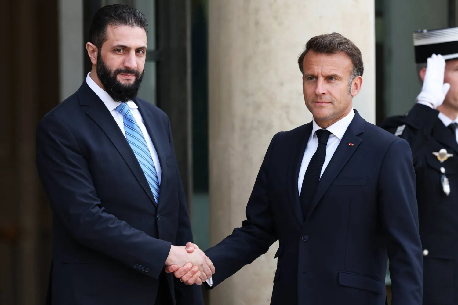 ماكرون مستقبلاً الشرع على مدخل قصر الإليزيه في باريس (أرشيفية - إ.ب.أ)